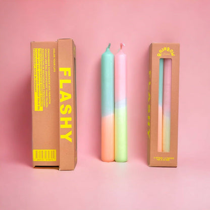 Rainbow Studio Dinner Candle Set Flashy — two dip-dyed pastel taper candles in mint-peach and pink-mint gradients, shown beside kraft packaging