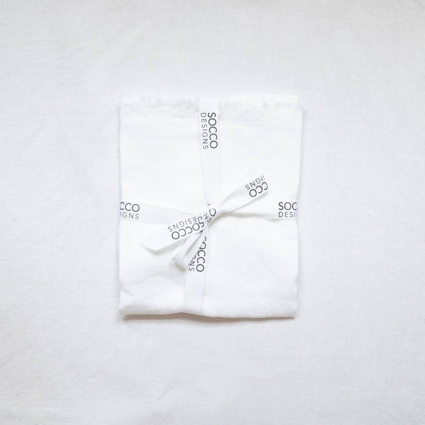 Close-up of the white fringed linen lumbar pillow cover showing the frayed edge texture