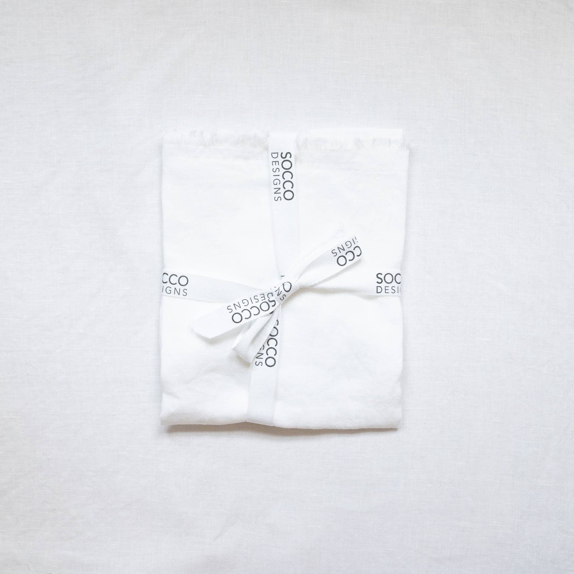 Close-up of the white fringed linen lumbar pillow cover showing the frayed edge texture
