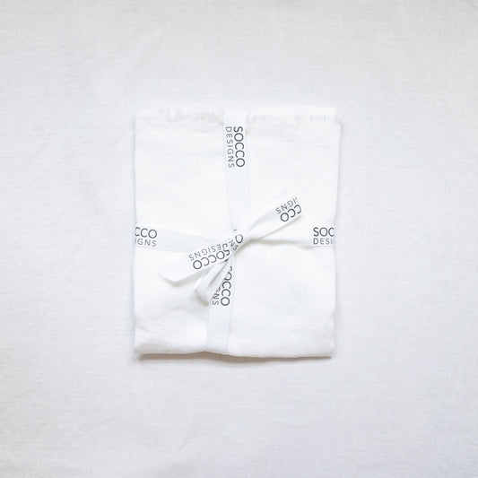 Close-up of the white fringed linen lumbar pillow cover showing the frayed edge texture