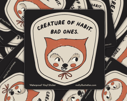 Matte vinyl sticker illustrated with a fox-like creature face and the text 'Creature of Habit, Bad Ones' on a cream background