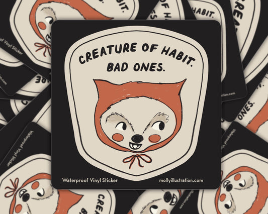 Matte vinyl sticker illustrated with a fox-like creature face and the text 'Creature of Habit, Bad Ones' on a cream background