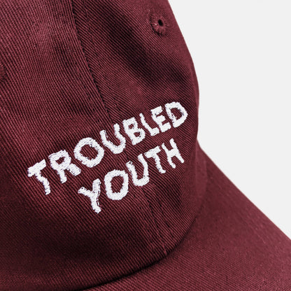 Side view of Troubled Youth burgundy dad hat showing adjustable metal clasp - PABOOM