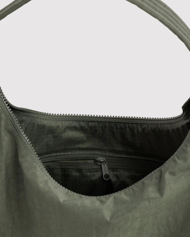 Close-up of the quilted strap and key leash on the BAGGU Nylon Shoulder Bag in caper green