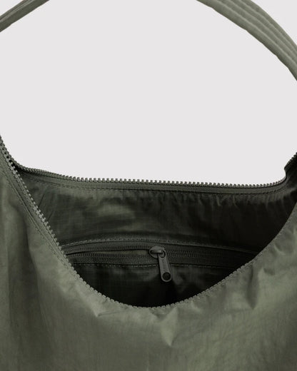 Close-up of the quilted strap and key leash on the BAGGU Nylon Shoulder Bag in caper green