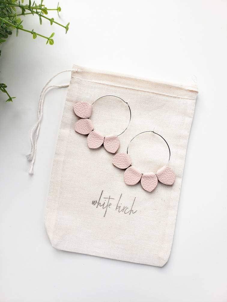Blush pink leather petal hoop earrings flat lay