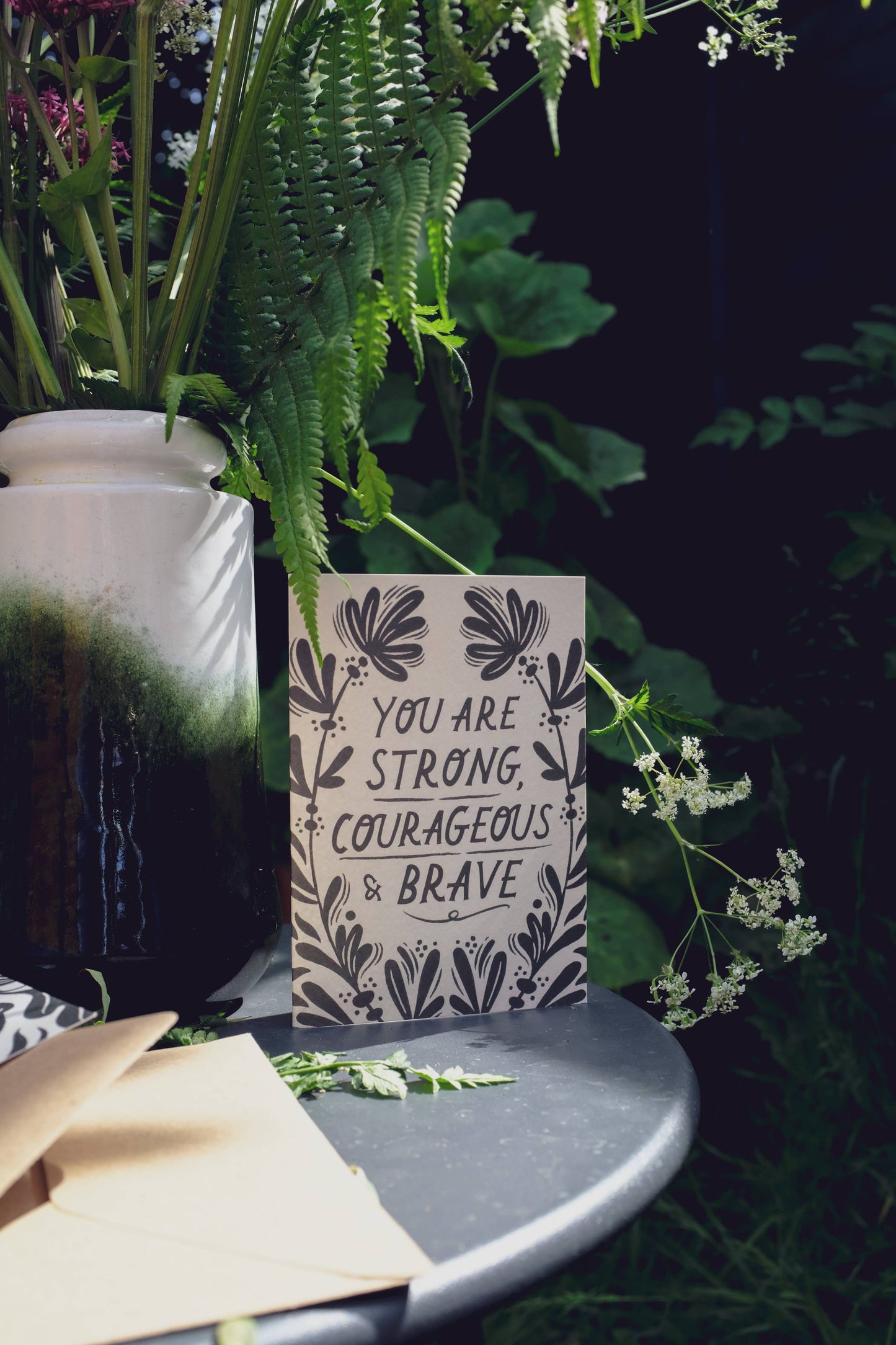 Close-up of the floral linework border on 'Strong, Courageous & Brave' card