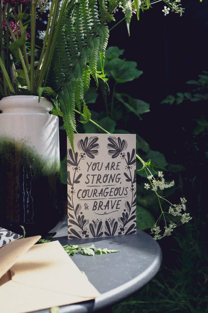 Close-up of the floral linework border on 'Strong, Courageous & Brave' card