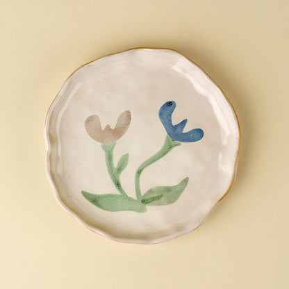 Cream stoneware plate hand-painted with pink and blue florals and a dotted blue rim