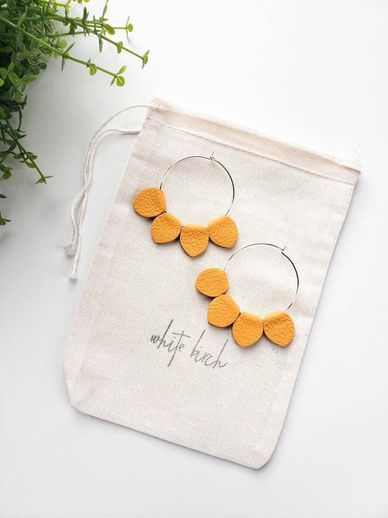 Mustard yellow leather petal hoop earrings flat lay