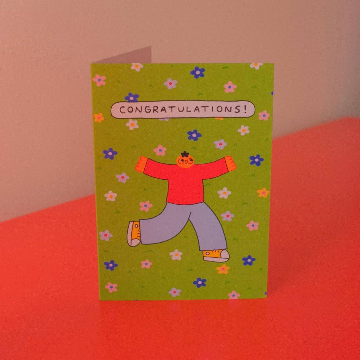 Congratulations greeting card illustrated with a celebrating character on a green floral background - PABOOM