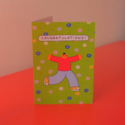 Congratulations greeting card illustrated with a celebrating character on a green floral background - PABOOM
