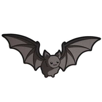 Grey vinyl die-cut sticker of a cute cartoon bat with wide-spread wings and a smiling face on a white background