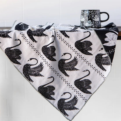 Swan Song dishtowel folded and styled on a kitchen counter – PABOOM