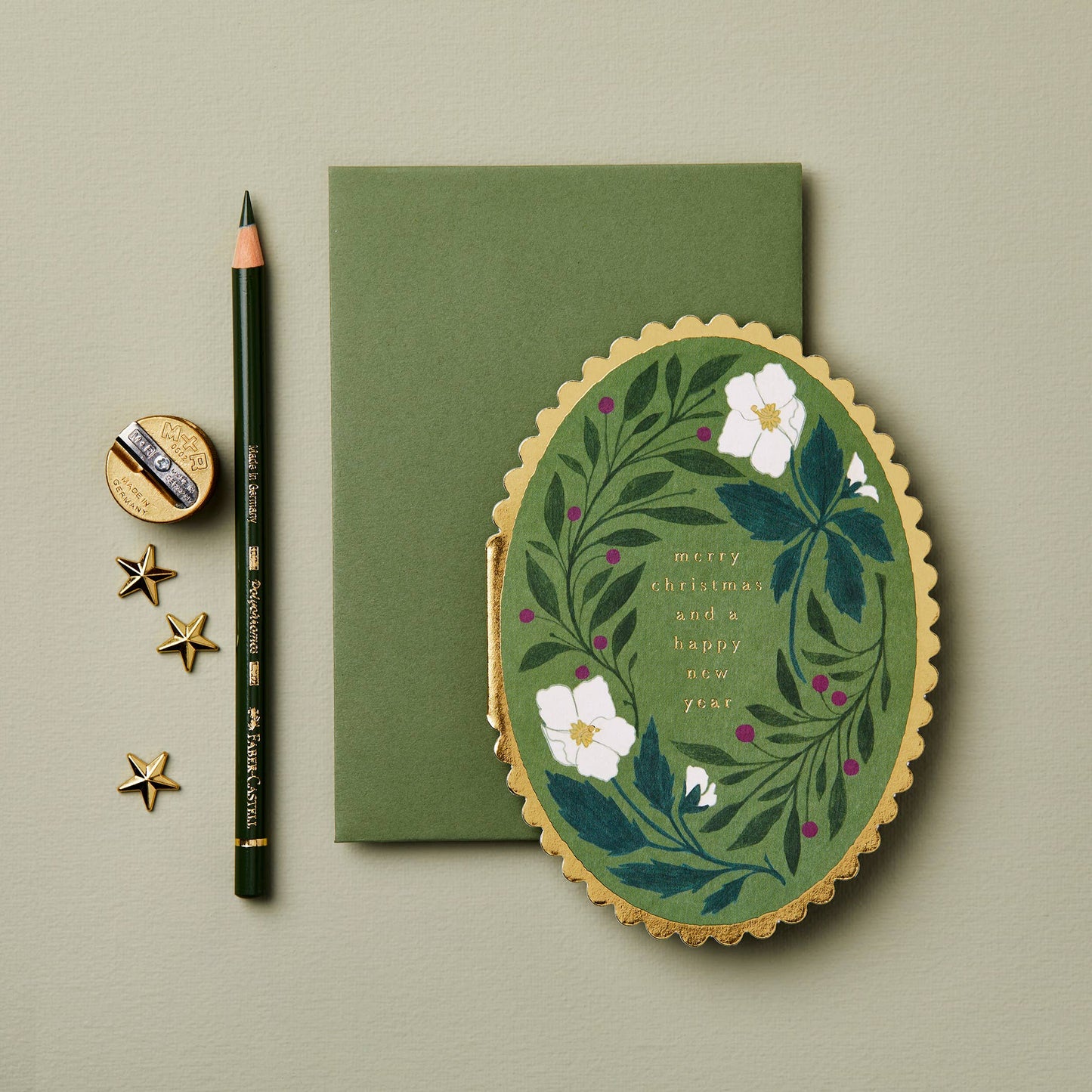 Green Flora Merry Christmas card styled with festive gift wrap
