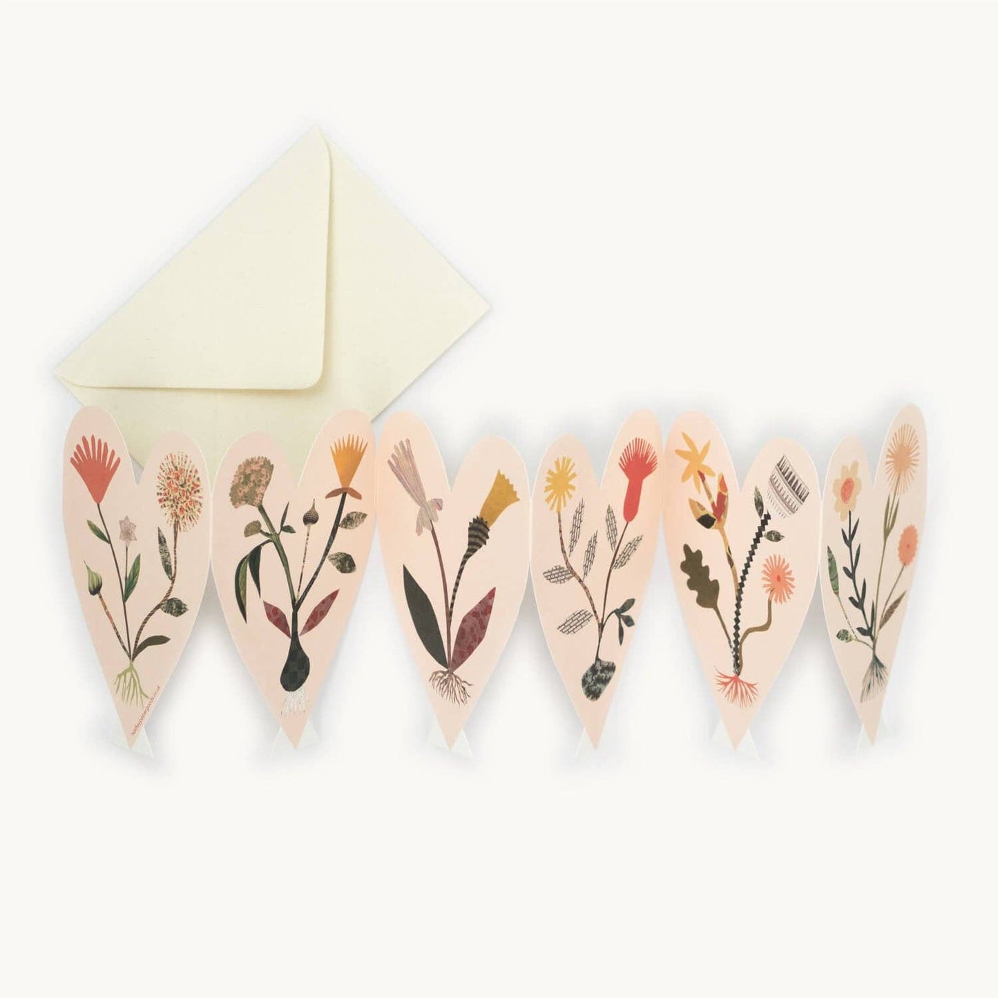 Six connected heart-shaped card panels, each hand-collaged with a different wildflower illustration in earthy tones, fanned out beside a cream envelope