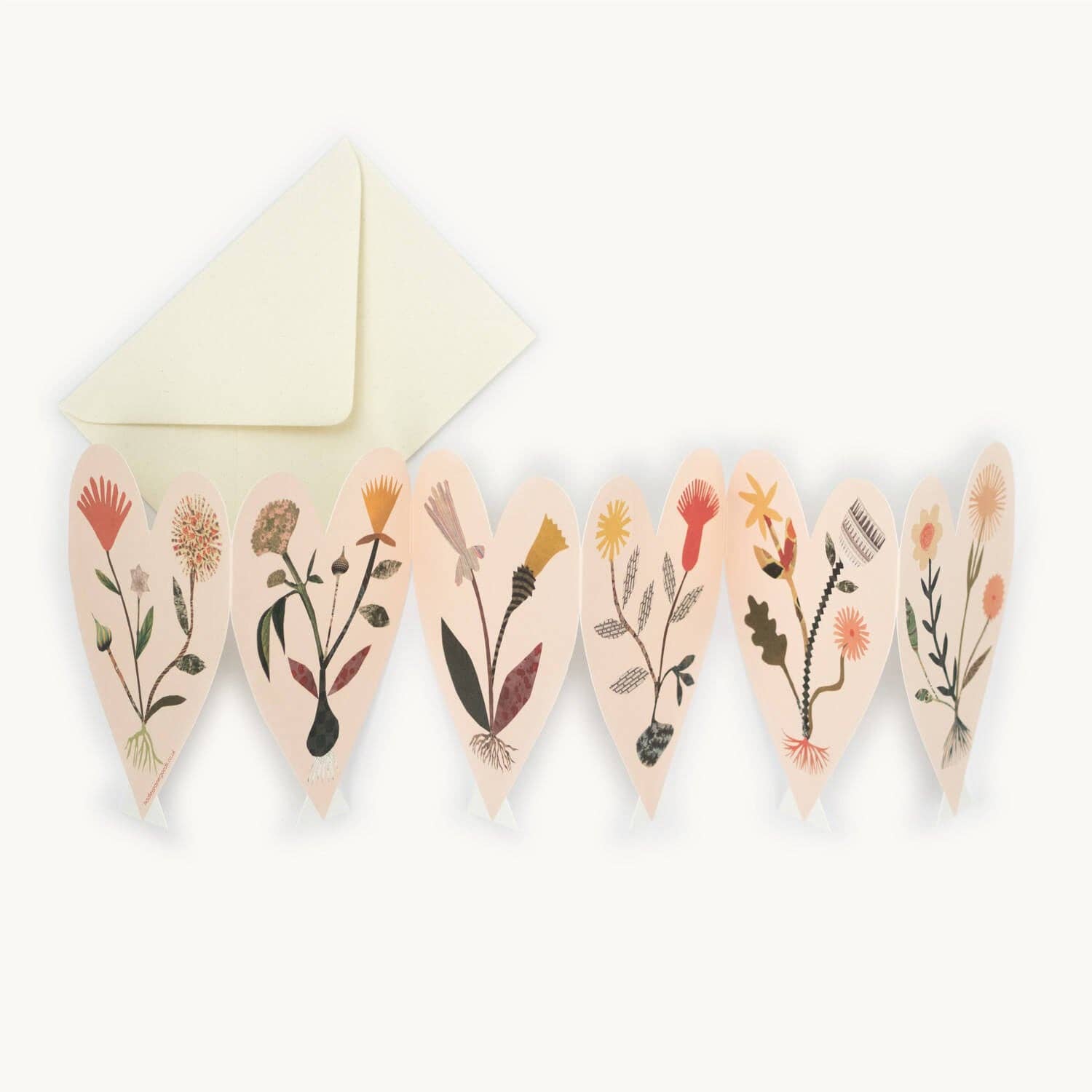 Six connected heart-shaped card panels, each hand-collaged with a different wildflower illustration in earthy tones, fanned out beside a cream envelope