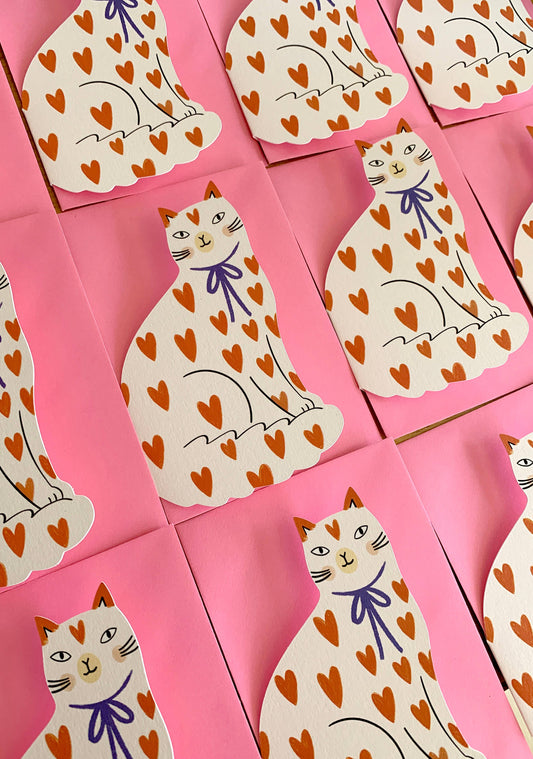 Kitty Kenda shaped sitting cat greeting card with an orange heart-print pattern