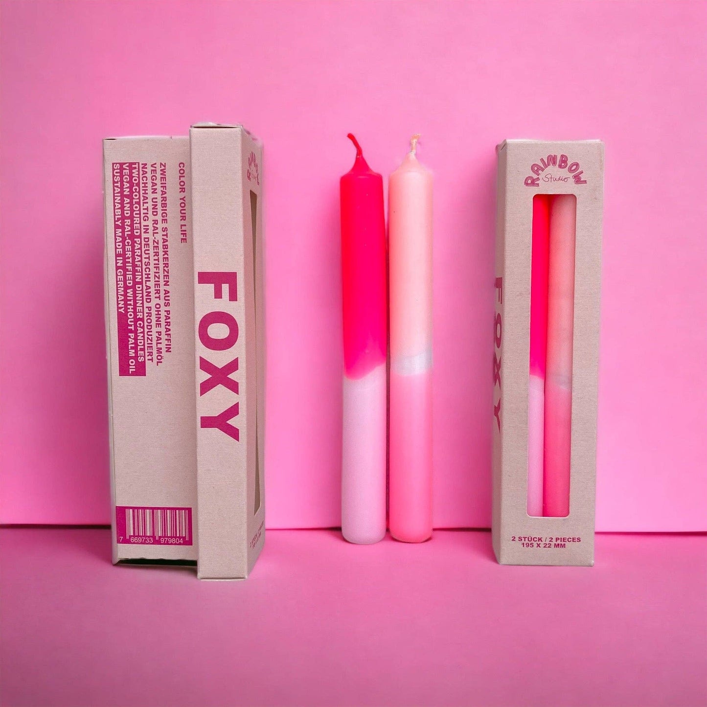 Rainbow Studio Dinner Candle Set Foxy — two dip-dyed taper candles in pink-to-white gradients, shown beside kraft packaging