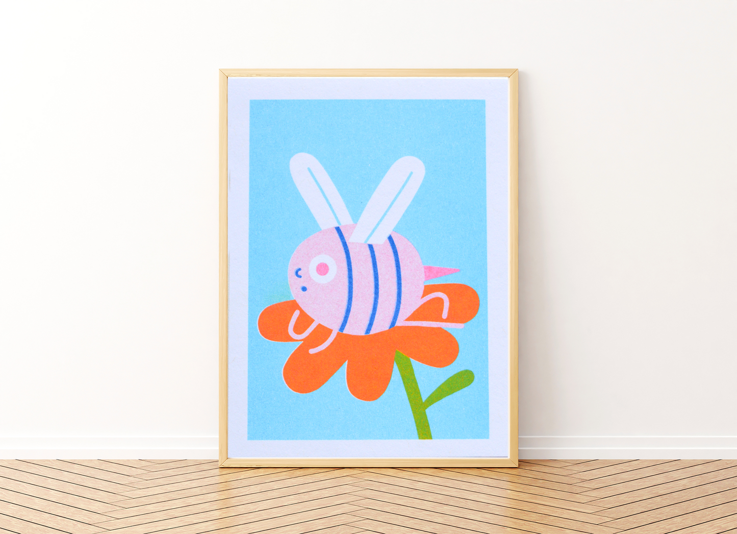 Mini Bee Risograph Print — illustration of a pink striped bee lounging on an orange flower, shown framed on light blue background