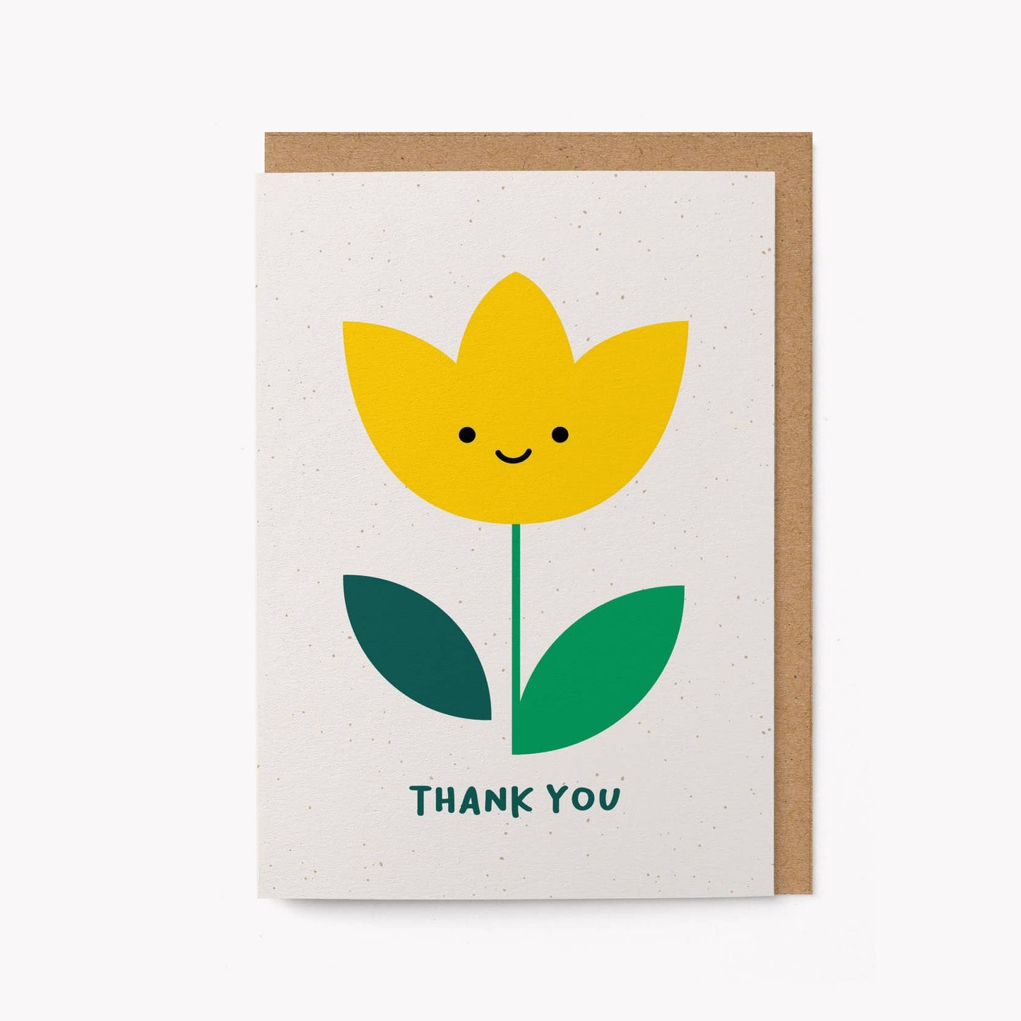 Cream greeting card with an illustrated smiling yellow tulip and the words 'THANK YOU' in green, kraft envelope alongside
