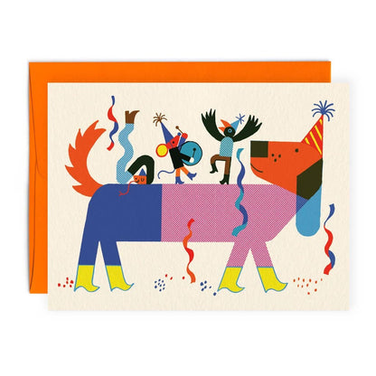 Two-toned illustrated dog in a party hat carrying three tiny costumed performers on its back, amid confetti and streamers