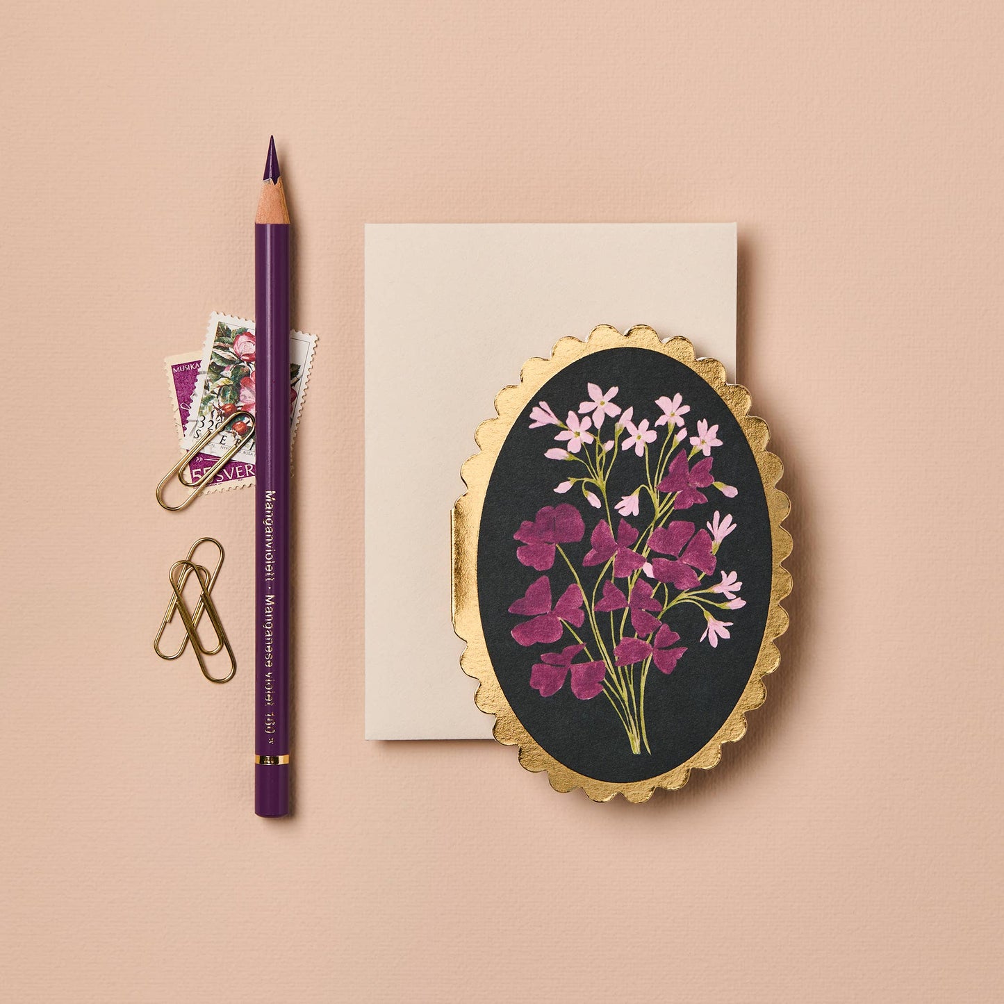 Magenta and pink oxalis flowers on black background, oval mini card with gold scalloped edge