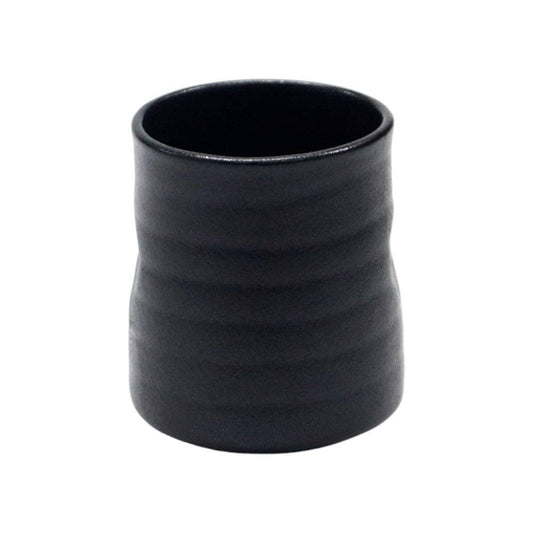 Matte black ceramic yunomi tea cup with a ribbed, hand-thrown texture and a slightly tapered silhouette