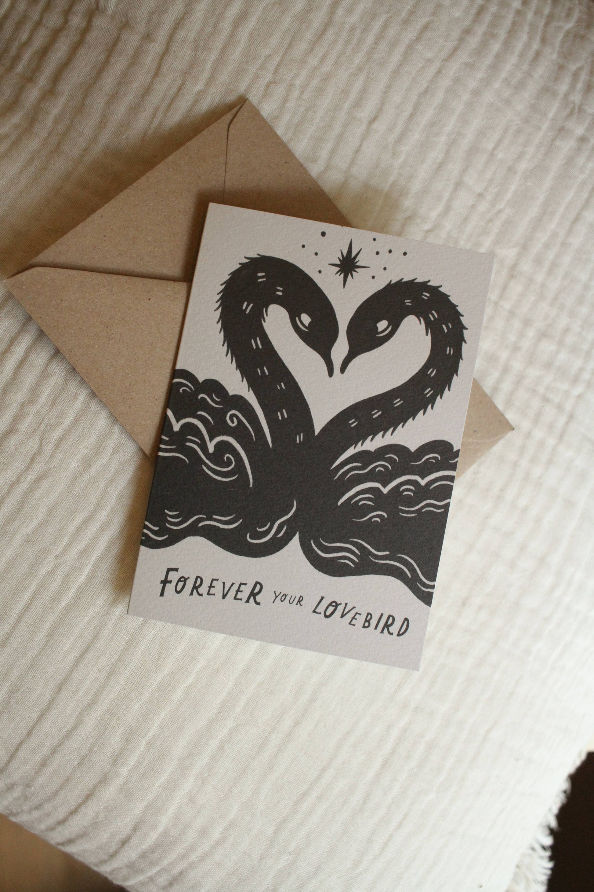 'Lovebirds' card with kraft envelope on a light background