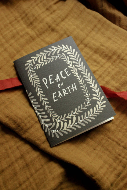 'Peace on Earth' card shown at an angle with envelope, highlighting the card's texture