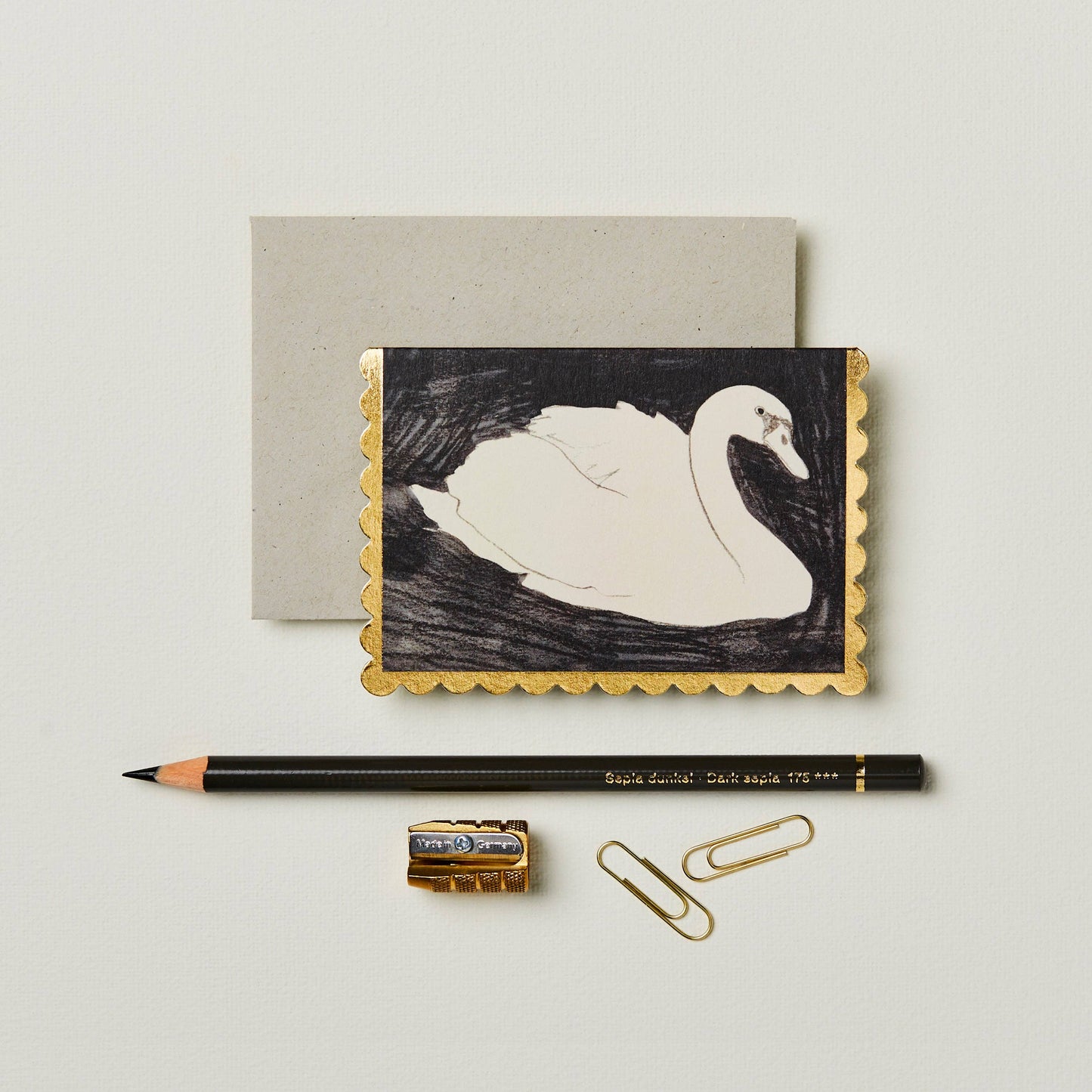 Black and white illustrated swan mini card with a gold foil scalloped edge