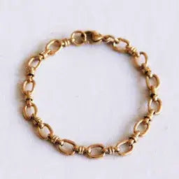 Gold-tone stainless steel link bracelet with elegant open oval chain links, laid flat - PABOOM