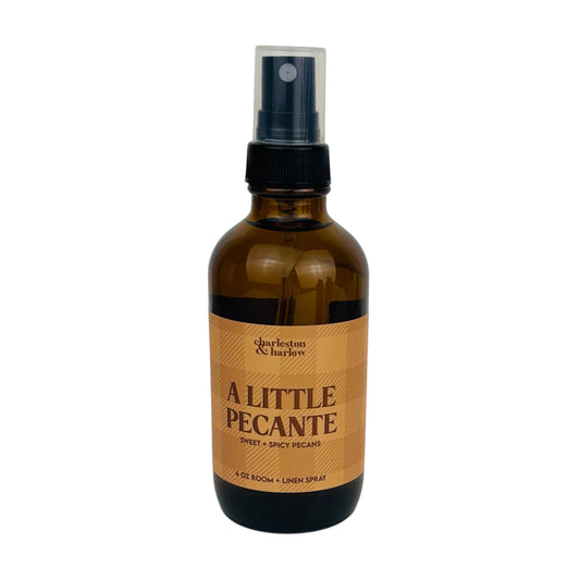 Amber glass spray bottle of Charleston & Harlow A Little Pecanté room and linen spray with tan plaid label