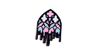 Black nickel enamel pin shaped like a gothic cathedral window with pink, white, and blue stained-glass pattern and a dripping black base