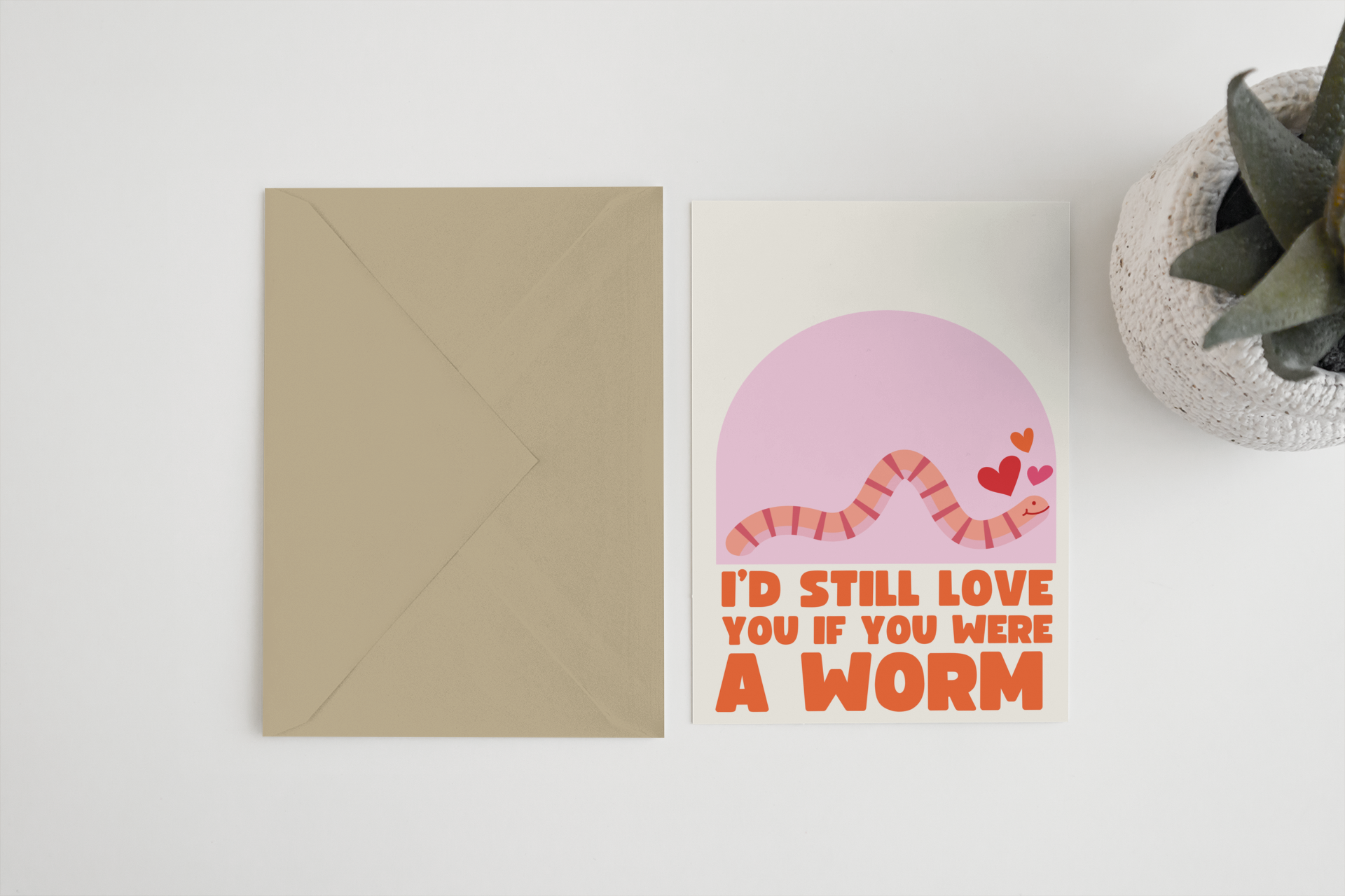 Blue Iris Designs Co card with pink background, cartoon pink worm with hearts, text "I'd Still Love You If You Were A Worm" beside a kraft envelope - PABOOM