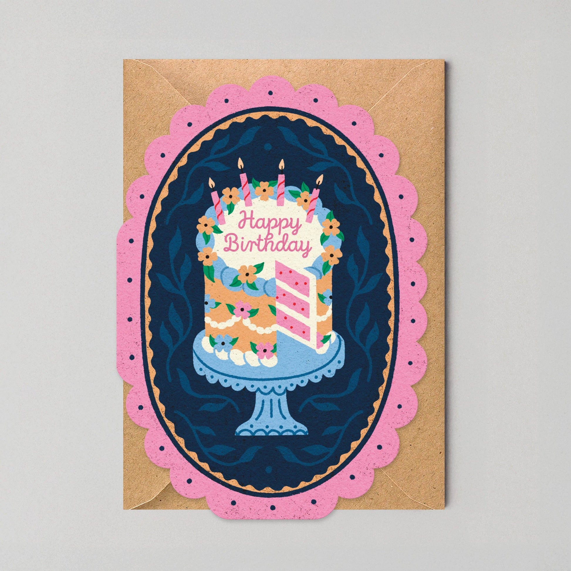 Die-cut birthday card with a scalloped pink frame around an illustrated pink layered birthday cake with lit candles on a navy background.