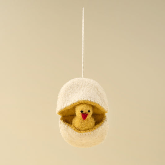 Tiny yellow felt chick peeking out of a white felt eggshell ornament