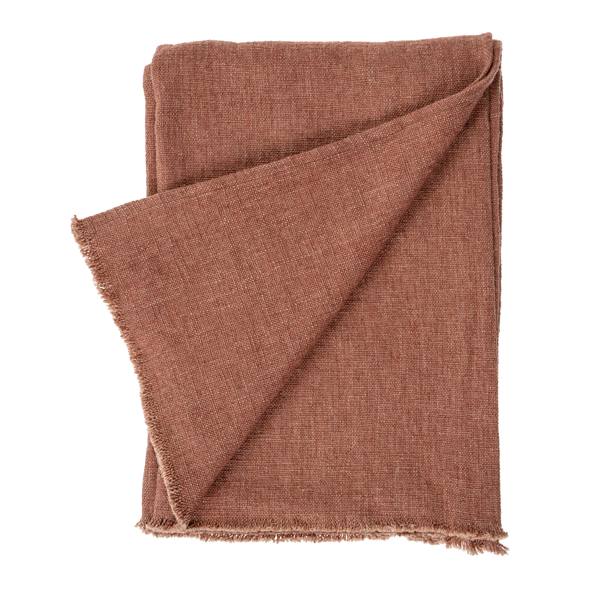 Rust-brick woven linen blanket with fringed edges, draped over the end of a bed