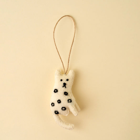 White felt cat ornament with hand-stitched black spots and whiskers