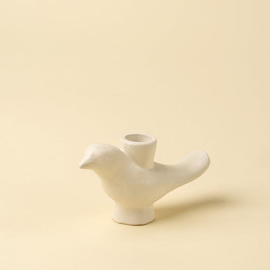 Sculptural ivory-finished aluminum candle holder shaped like a perched bird