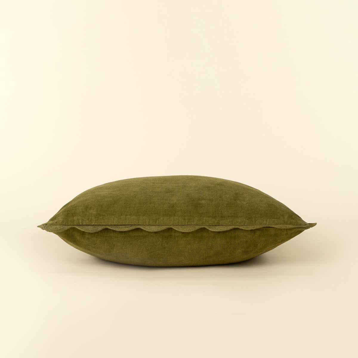 Corduroy Scallop Pillow in Moss styled on a sofa
