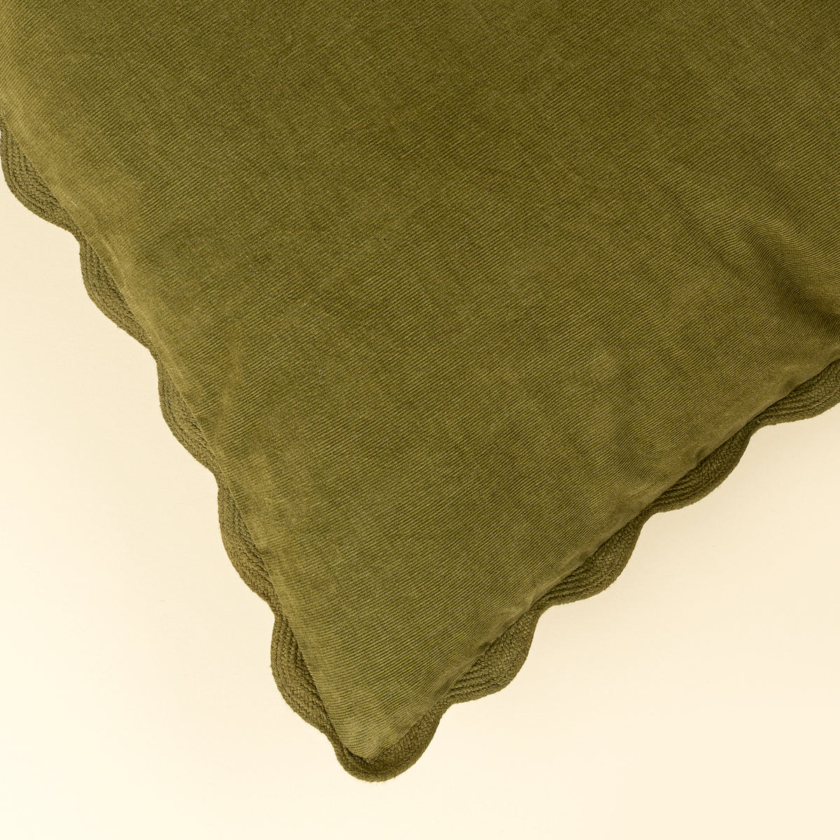Close-up of the tone-on-tone scalloped edge on the Corduroy Scallop Pillow in Moss