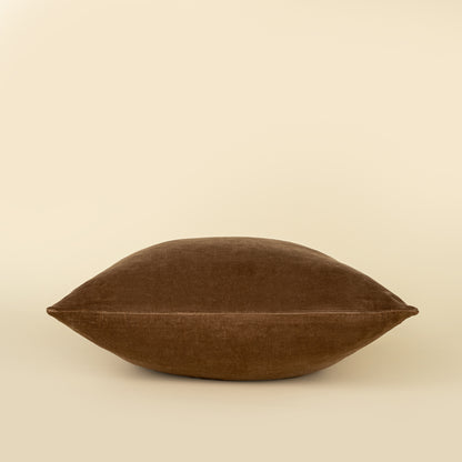 Vera Luxe Velvet Pillow in Caramel styled on a sofa