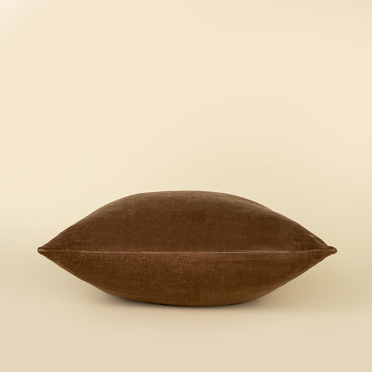 Vera Luxe Velvet Pillow in Caramel styled on a sofa