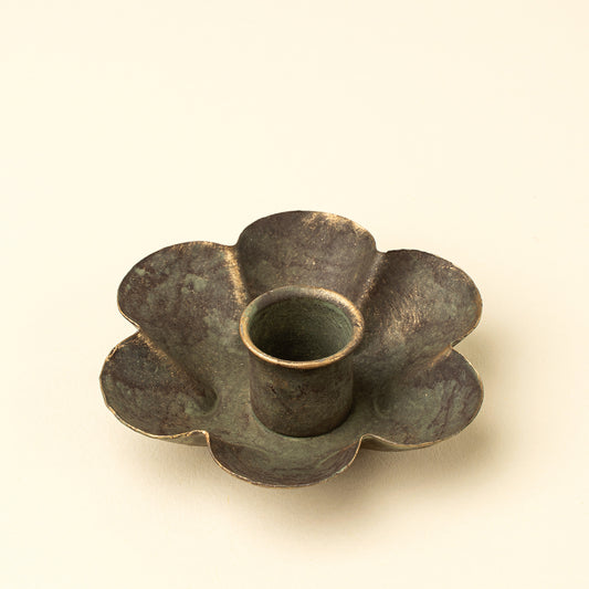 Daisy-shaped iron candle holder with a green patina finish