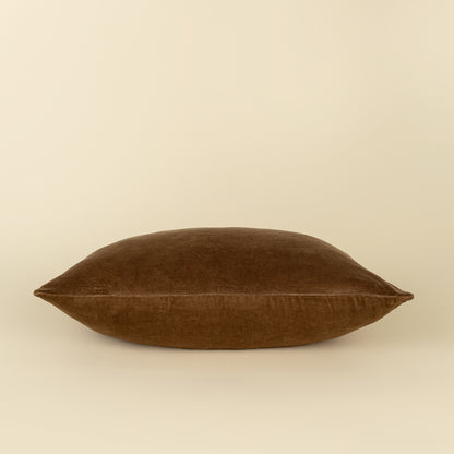 Vera Luxe Velvet Pillow in Caramel styled on a sofa