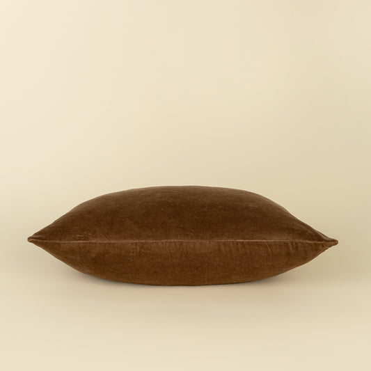 Vera Luxe Velvet Pillow in Caramel styled on a sofa