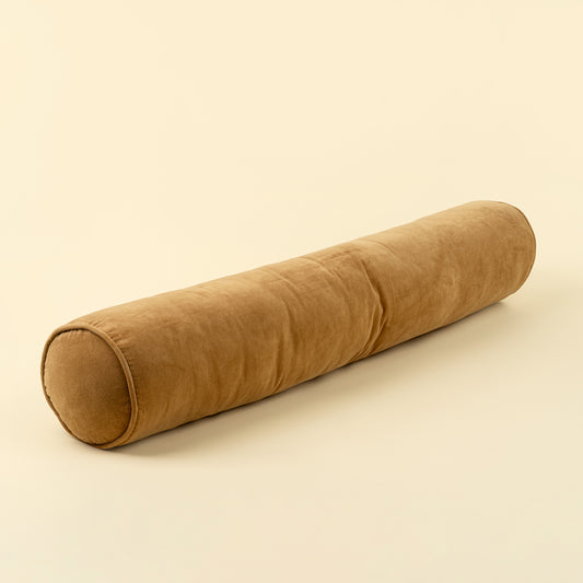 Long cylindrical tan-gold velvet bolster pillow