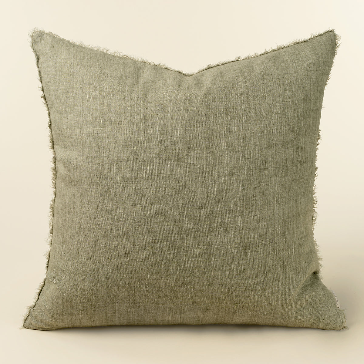 Square sage green linen pillow with a frayed, fringed edge
