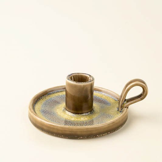 Round reactive glaze candle holder with a looped handle in brown and gold tones